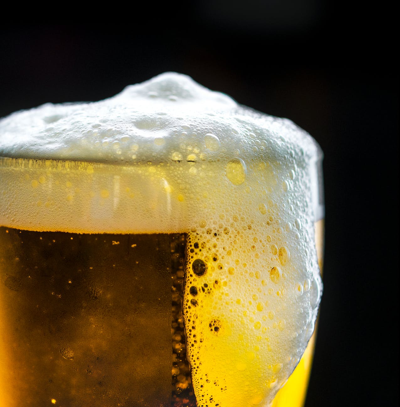photo of glass overflowing with beer